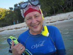 Barbara Crites in snorkeling gear ready to dive into the ocean. 